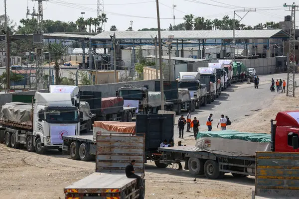 A convoy of aid trucks enters Gaza through the Rafah crossing. (New York Times)